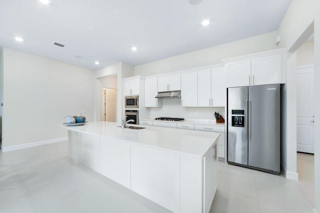 kitchen featuring a kitchen island with sink, under cabinet range hood, white cabinetry, appliances with stainless steel finishes, and light countertops