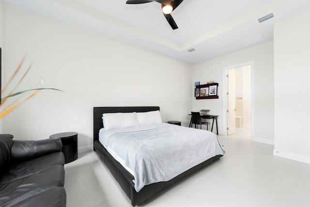 bedroom with a ceiling fan, a tray ceiling, baseboards, and visible vents