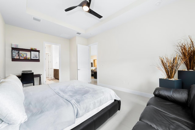 bedroom featuring a tray ceiling, baseboards, visible vents, and ceiling fan