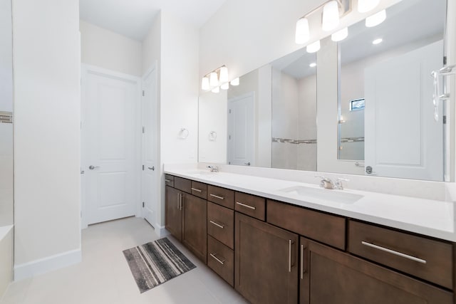 bathroom featuring double vanity, baseboards, and a sink