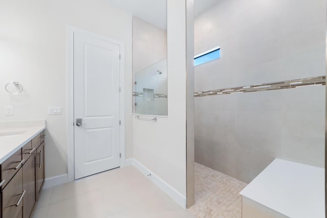 bathroom featuring baseboards, vanity, and walk in shower