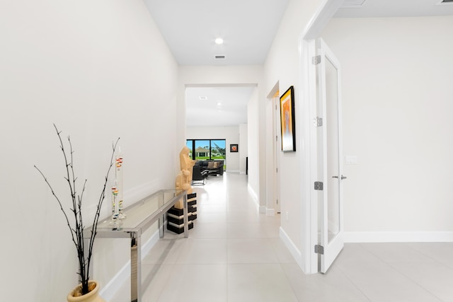 hallway with light tile patterned floors, visible vents, recessed lighting, and baseboards