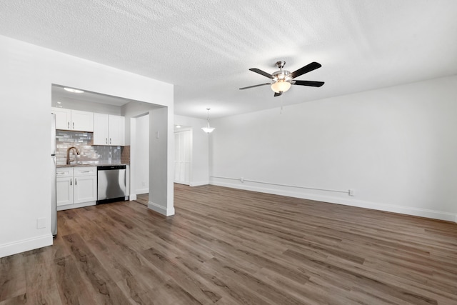 unfurnished living room with dark wood finished floors, a textured ceiling, ceiling fan, and a sink