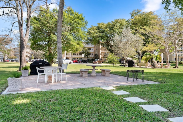 view of community with a yard and a patio