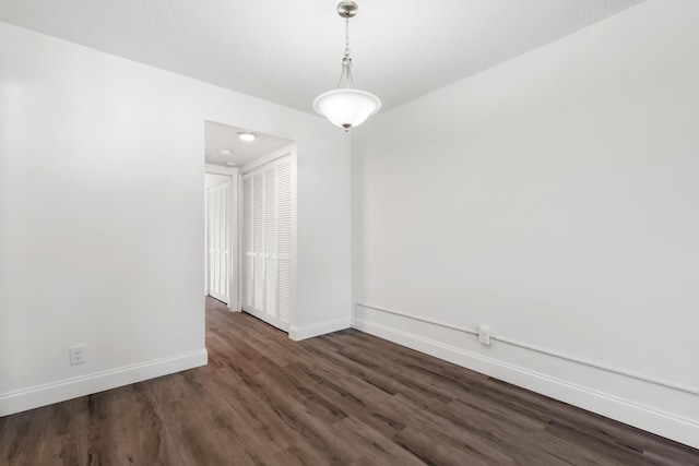 unfurnished room featuring baseboards and wood finished floors