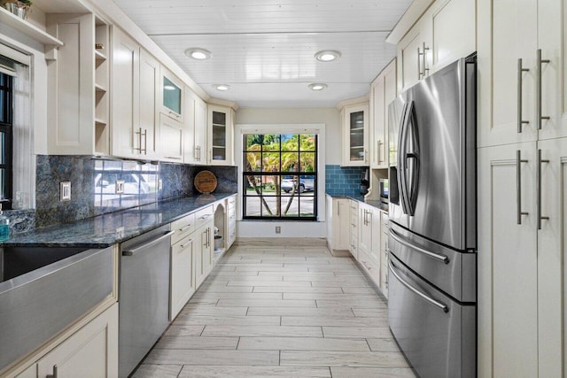 kitchen with open shelves, light wood finished floors, glass insert cabinets, and appliances with stainless steel finishes