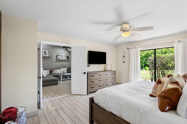 bedroom with a ceiling fan, access to outside, light wood-style floors, and a textured ceiling