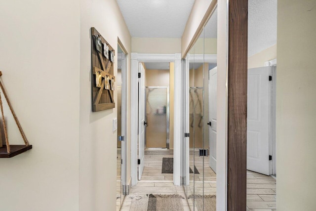 corridor with a textured ceiling and wood tiled floor