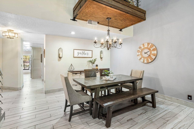 dining room with a notable chandelier, visible vents, baseboards, and wood tiled floor