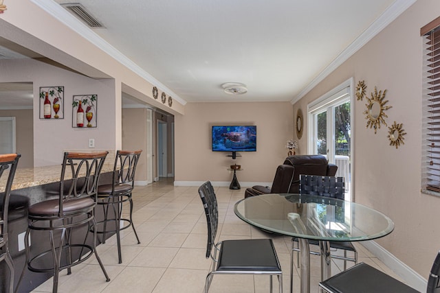 dining room with crown molding, light tile patterned floors, baseboards, and visible vents