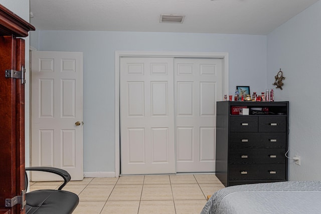 bedroom featuring visible vents, a closet, and light tile patterned flooring