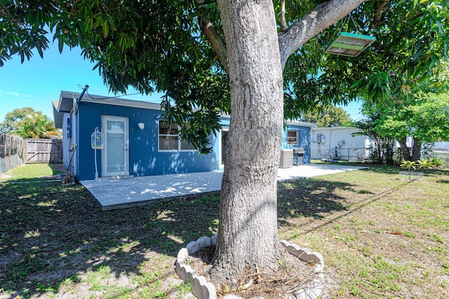 view of front of property featuring a patio area, a fenced backyard, a front lawn, and stucco siding