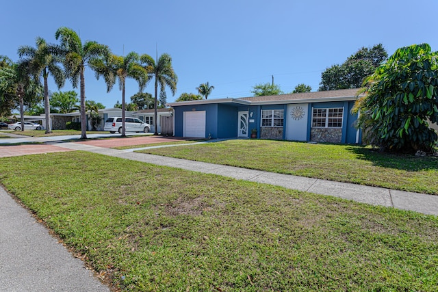 view of front of property featuring a front lawn, an attached garage, driveway, and stucco siding