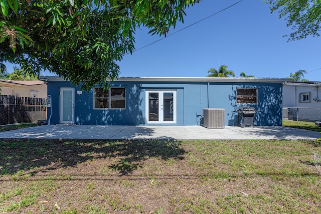 rear view of property with a patio, french doors, fence, and central AC