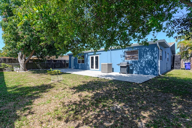 back of property with french doors, a patio, a lawn, and a fenced backyard