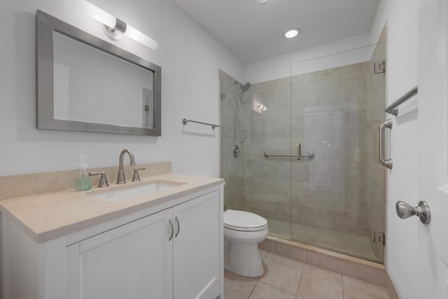 full bath with tile patterned flooring, a shower stall, toilet, and vanity