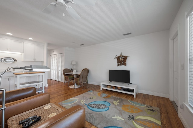 living room featuring recessed lighting, wood finished floors, baseboards, and ceiling fan