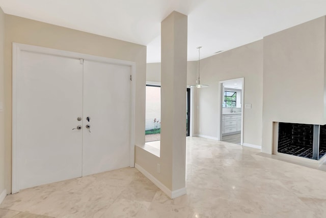 entrance foyer with a fireplace with flush hearth and baseboards