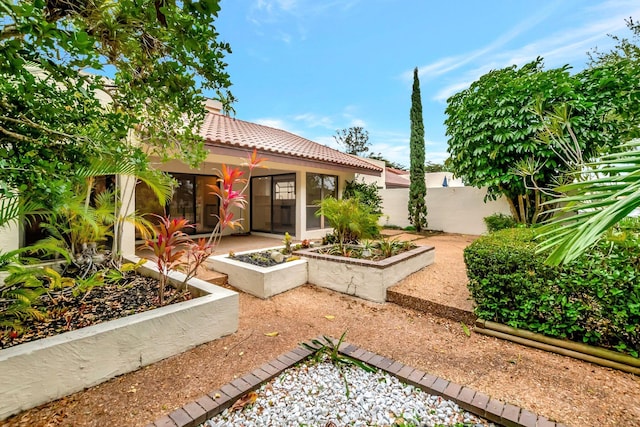 6740 Lago Vista Ter, Boca Raton, FL 33433 - view of front of property featuring fence, a garden, stucco siding, a tiled roof, and a patio area