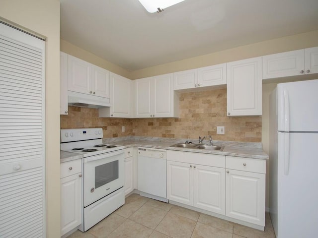 kitchen featuring under cabinet range hood, light countertops, decorative backsplash, white appliances, and a sink