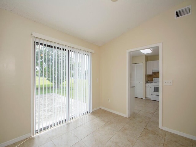 empty room with visible vents, baseboards, light tile patterned flooring, and vaulted ceiling