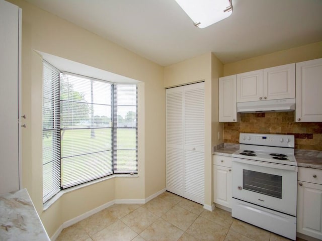 kitchen featuring electric range, under cabinet range hood, tasteful backsplash, white cabinetry, and light tile patterned floors