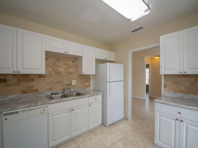 kitchen featuring visible vents, backsplash, white cabinets, white appliances, and a sink