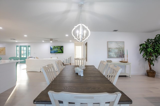 dining area featuring visible vents, light wood-style flooring, ceiling fan with notable chandelier, recessed lighting, and baseboards