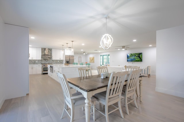 dining area with a chandelier, recessed lighting, and light wood-type flooring