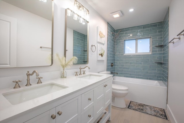 full bathroom with bathing tub / shower combination, toilet, double vanity, and a sink