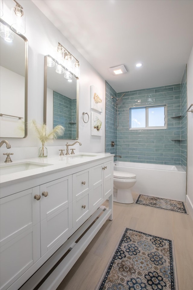 bathroom with double vanity, toilet, bathtub / shower combination, and a sink