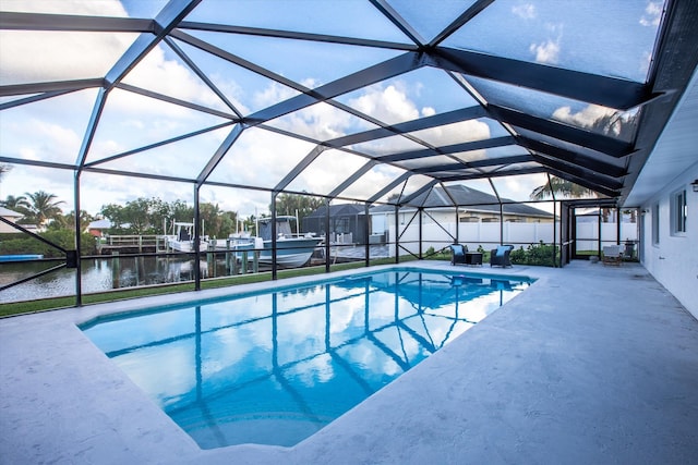 pool featuring a patio, fence, a water view, and a lanai