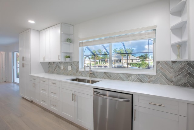 kitchen featuring white cabinetry, open shelves, a sink, light countertops, and stainless steel dishwasher