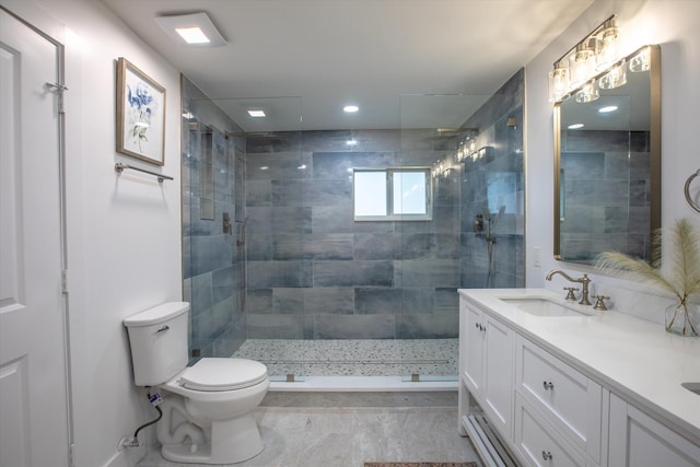 full bathroom with tiled shower, toilet, and a sink