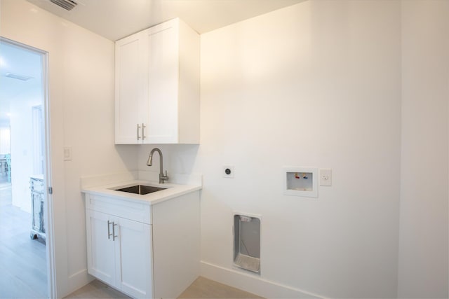 washroom featuring electric dryer hookup, visible vents, a sink, cabinet space, and hookup for a washing machine