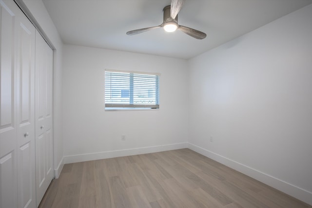 unfurnished bedroom featuring a closet, a ceiling fan, light wood-type flooring, and baseboards