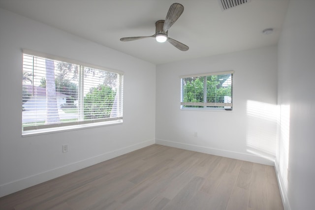 spare room with visible vents, ceiling fan, baseboards, and light wood-style floors