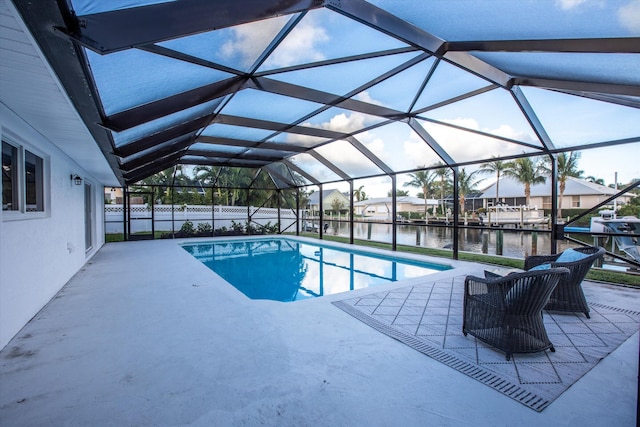 pool featuring a patio area, glass enclosure, and a water view