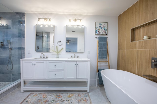 bathroom with double vanity, a tile shower, a freestanding bath, and a sink