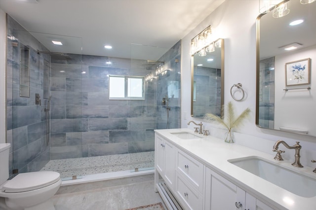 bathroom with a tile shower, toilet, and a sink