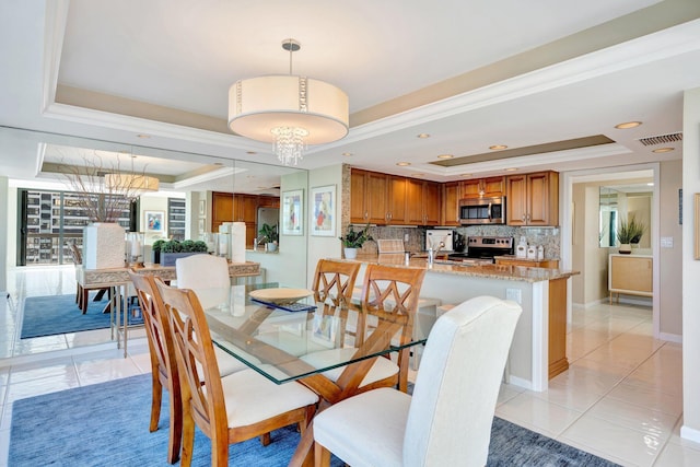 dining area featuring light tile patterned flooring, visible vents, a raised ceiling, and an inviting chandelier