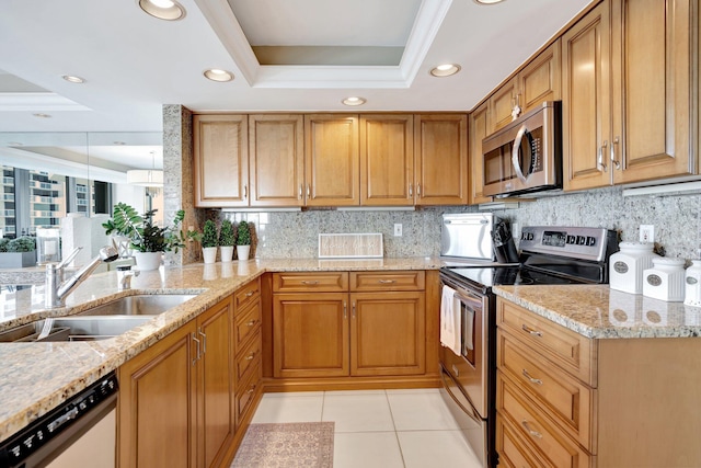 kitchen featuring a sink, a tray ceiling, backsplash, appliances with stainless steel finishes, and light tile patterned floors