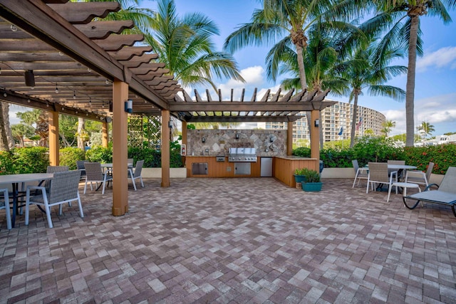 view of patio / terrace featuring exterior kitchen, a grill, outdoor dining space, and a pergola