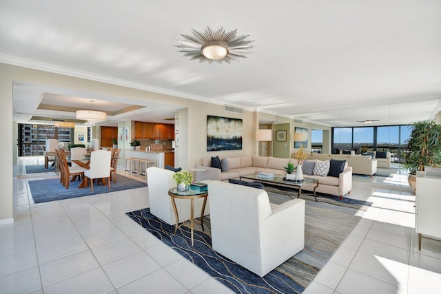 living area with light tile patterned floors, visible vents, crown molding, and a raised ceiling