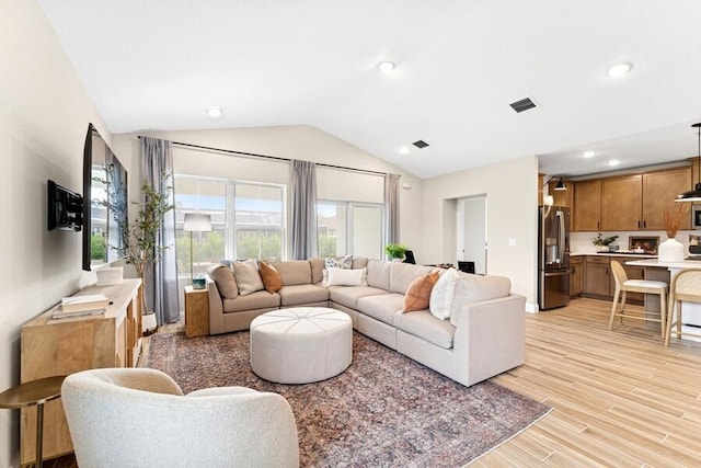 living room featuring recessed lighting, visible vents, lofted ceiling, and light wood-style floors