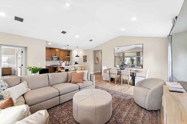 living area with baseboards, visible vents, lofted ceiling, recessed lighting, and light wood-type flooring