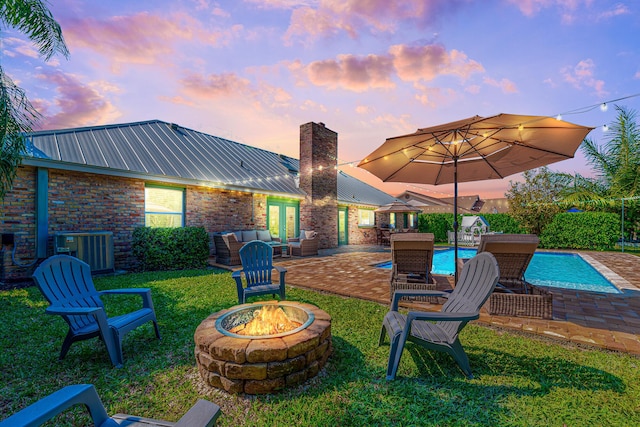 view of yard with a patio area, an outdoor pool, cooling unit, and an outdoor fire pit