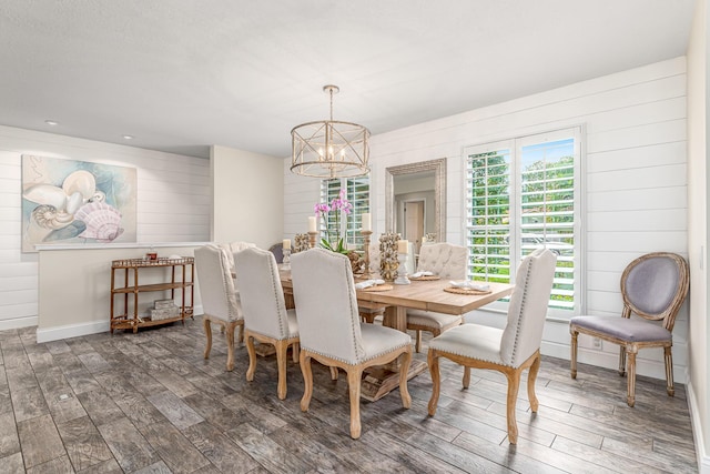 dining room with a chandelier, baseboards, and wood finished floors