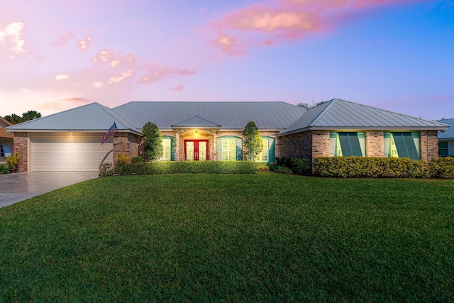 view of front facade with concrete driveway, an attached garage, brick siding, and a front yard