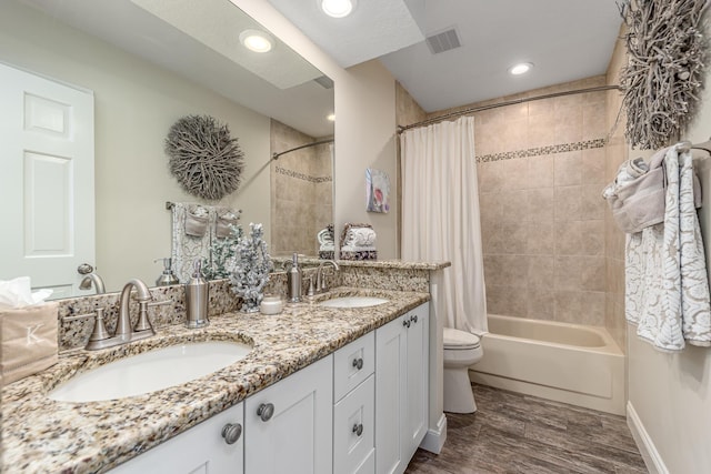 full bath featuring double vanity, shower / bathtub combination with curtain, visible vents, and a sink